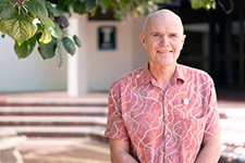 Richard Crane stands outside in a garden setting