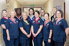 A group of ten Rockingham General Hospital midwifery staff stand togetehr in a hospital hallway