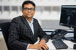 Professor Girish Dwivedi sits at a computer