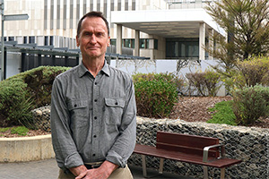 Dr Mike Christmass stands in a garden outside Fiona Stanley Hospital