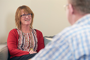A woman in conversation with a man who is facing away from the camera