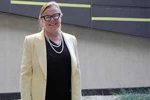 Professor Fiona Wood stands in front of coloured exterior wall panels