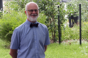 John McLachlan stands in a garden