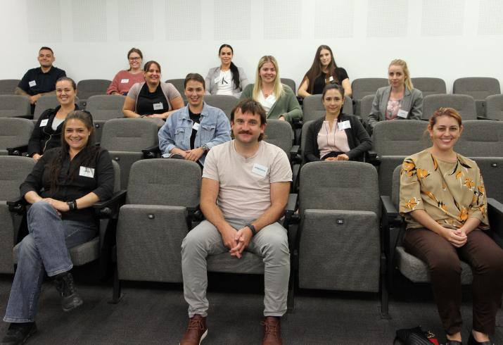 A group of 13 Aboriginal men and women sitting in a lecture theatre