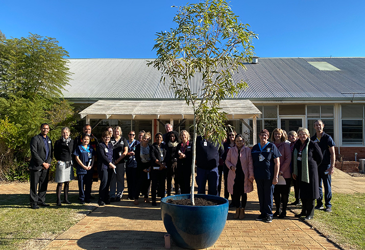 Group of people standing in front of hospital. 