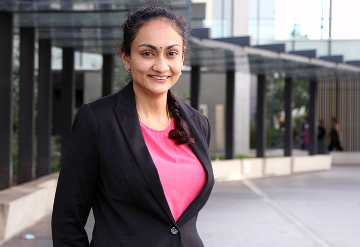 Dr Kavita Seth stands in front of a curved wall