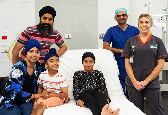 Child patient with her family and a surgeon and nurse.