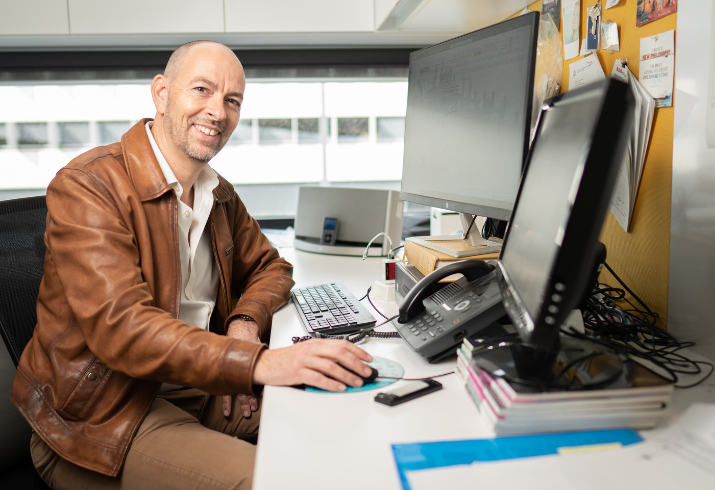 Professor Dickon Hayne at desk with computer