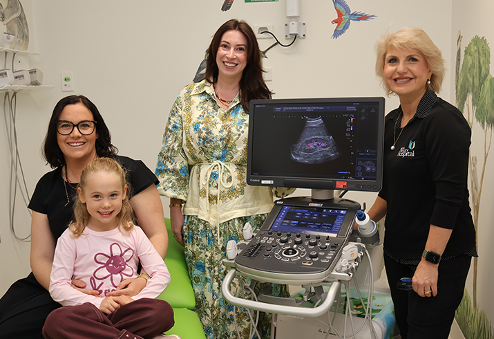 Mother Ashleigh Evans sitting with daughter Isla Wagstaff pictured with Andrea Chapman and sonographer Marilyn Zalesco standing around the ultrasound equipment.